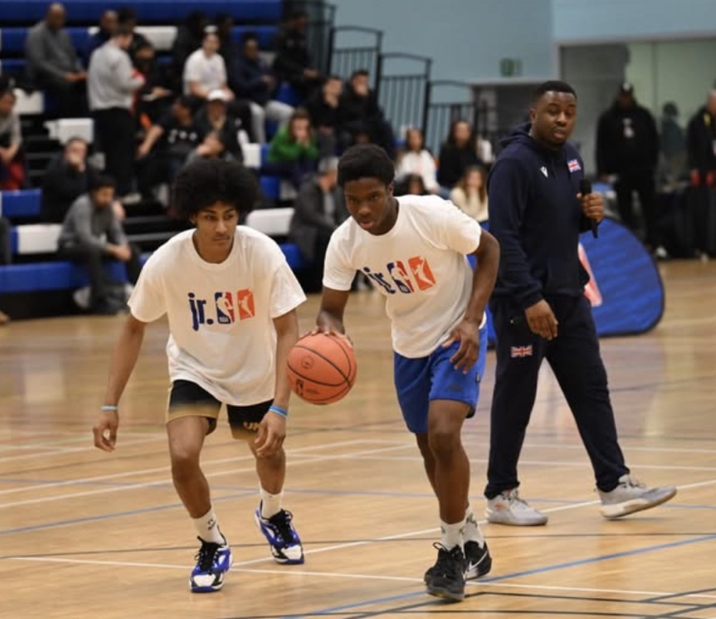 Players dribbling through a drill while coaches watch